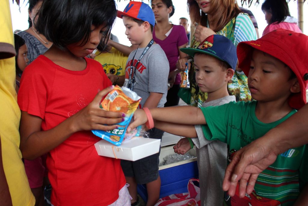 Oliver and his cousins handing out care packages to kids 