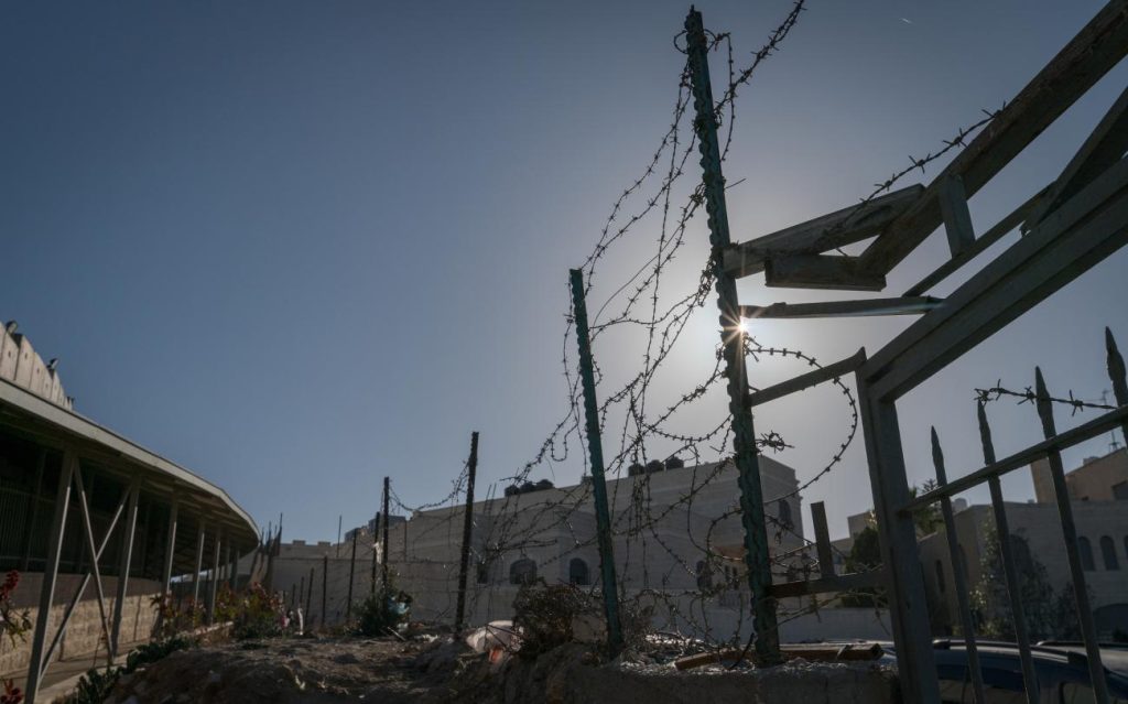 The sun shines through a section of a fence at checkpoint 300 in Bethlehem