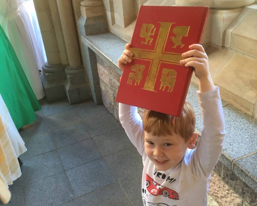 Child carrying Bible out of Cathedral 