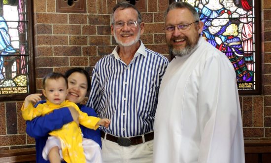 The Rev'd Dr John Rolley with Goondiwindi parishioners baby Anne and her parents Tien and Ross