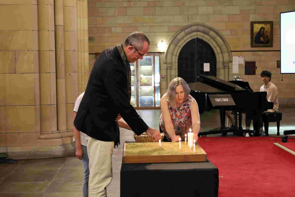 Bishop Cam Venables and Eve James lighting candles at the Sustainability Roadmap launch