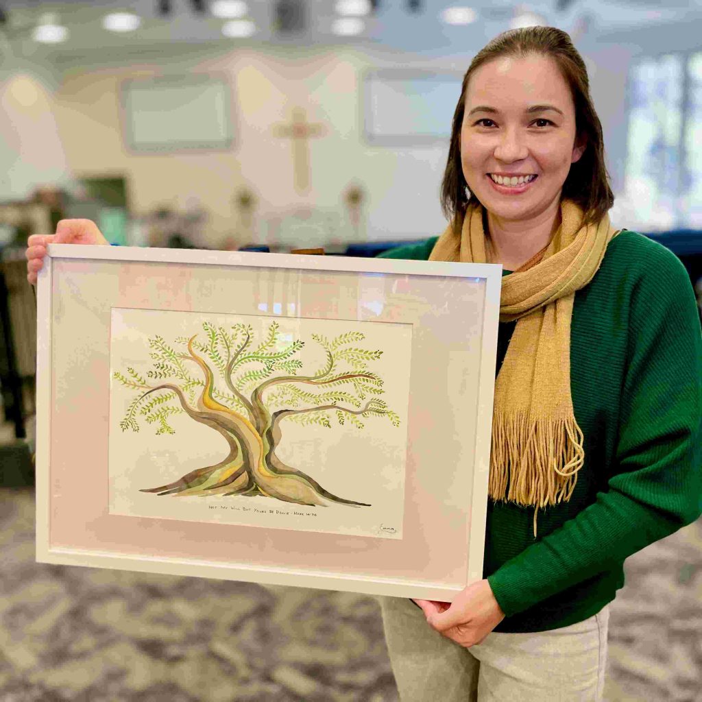 Emma Gardiner-Smith with a watercolour showing a tree with growing with new life