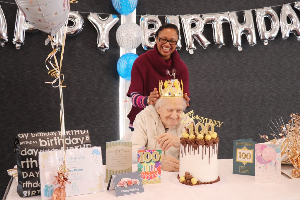 Sydney Bacon and an Anglicare staff member at his 100th birthday